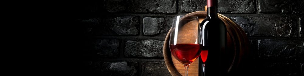 Copa de vino tinto, botella y barril